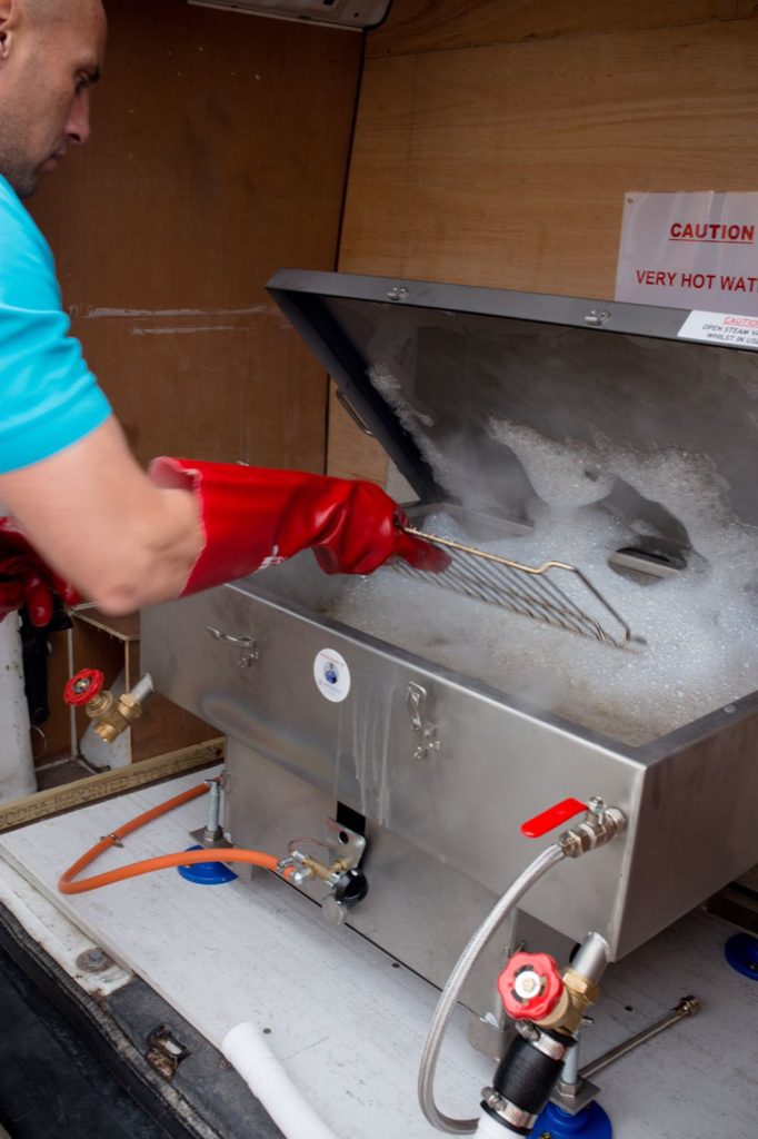 Oven Craft technician hand-dipping an oven rack in South Wales